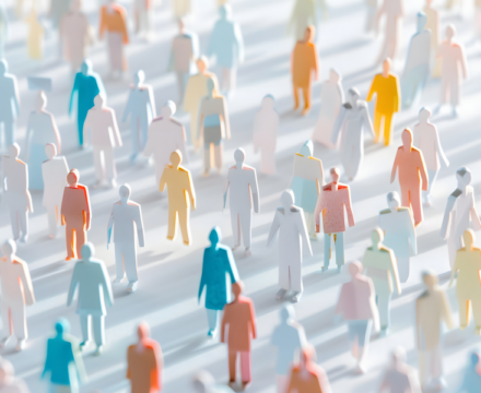 Paper cutout figures in various pastel colors stand in rows, casting long shadows on a white surface, representing a diverse crowd or community.